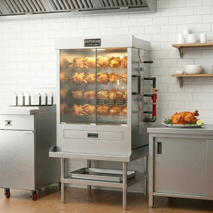 A commercial rotisserie oven inside a restaurant kitchen. The oven is full of cooking rotisserie chickens.