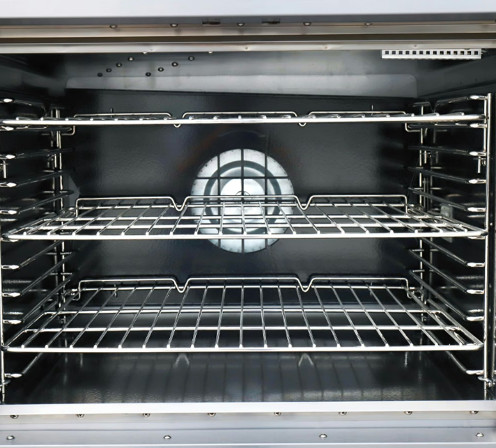 Three empty metal shelves inside a small commercial convection oven. The door to the convection oven is open.